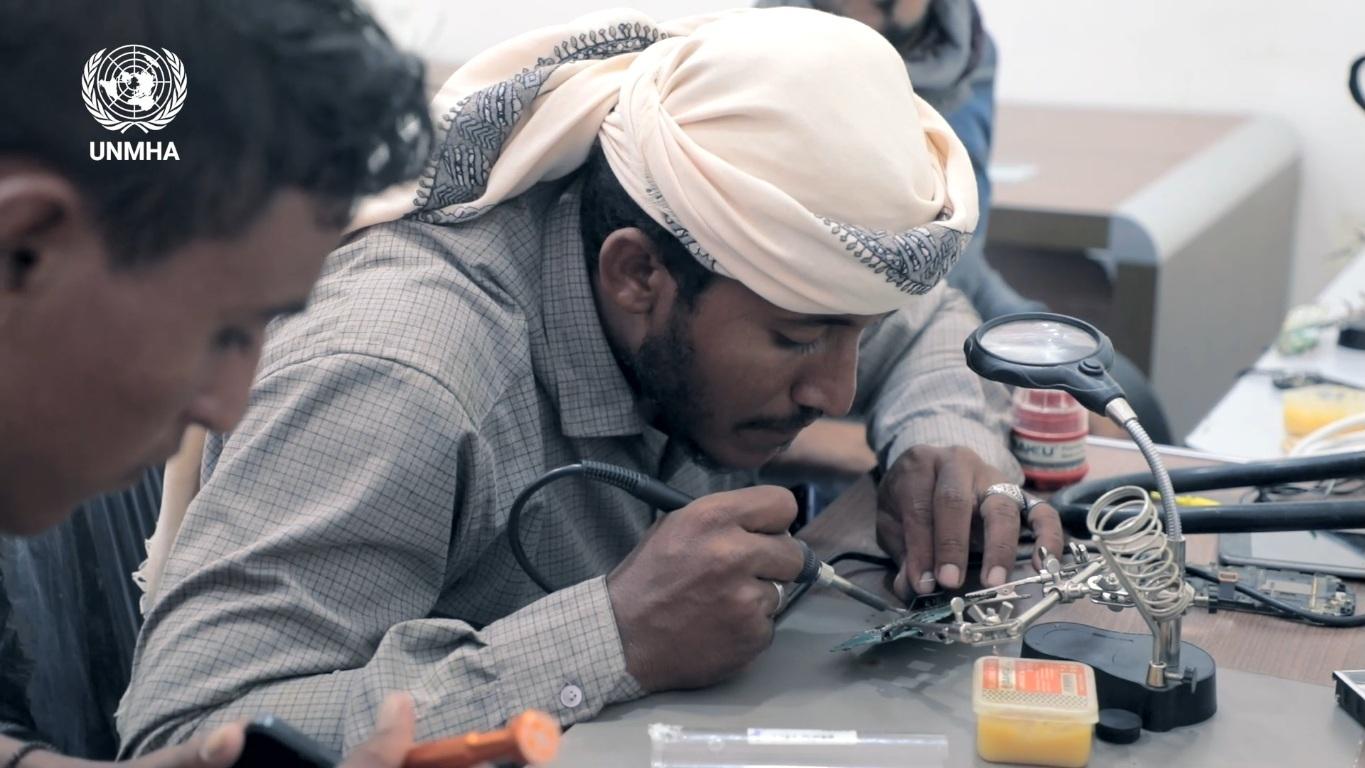 A man receives training in mobile phone repair A man receives training in mobile phone repair